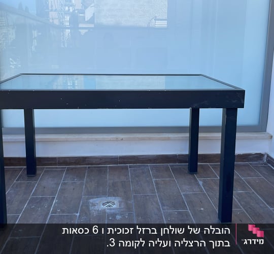 שולחן זכוכית עם רגליים שחורות על מרפסת